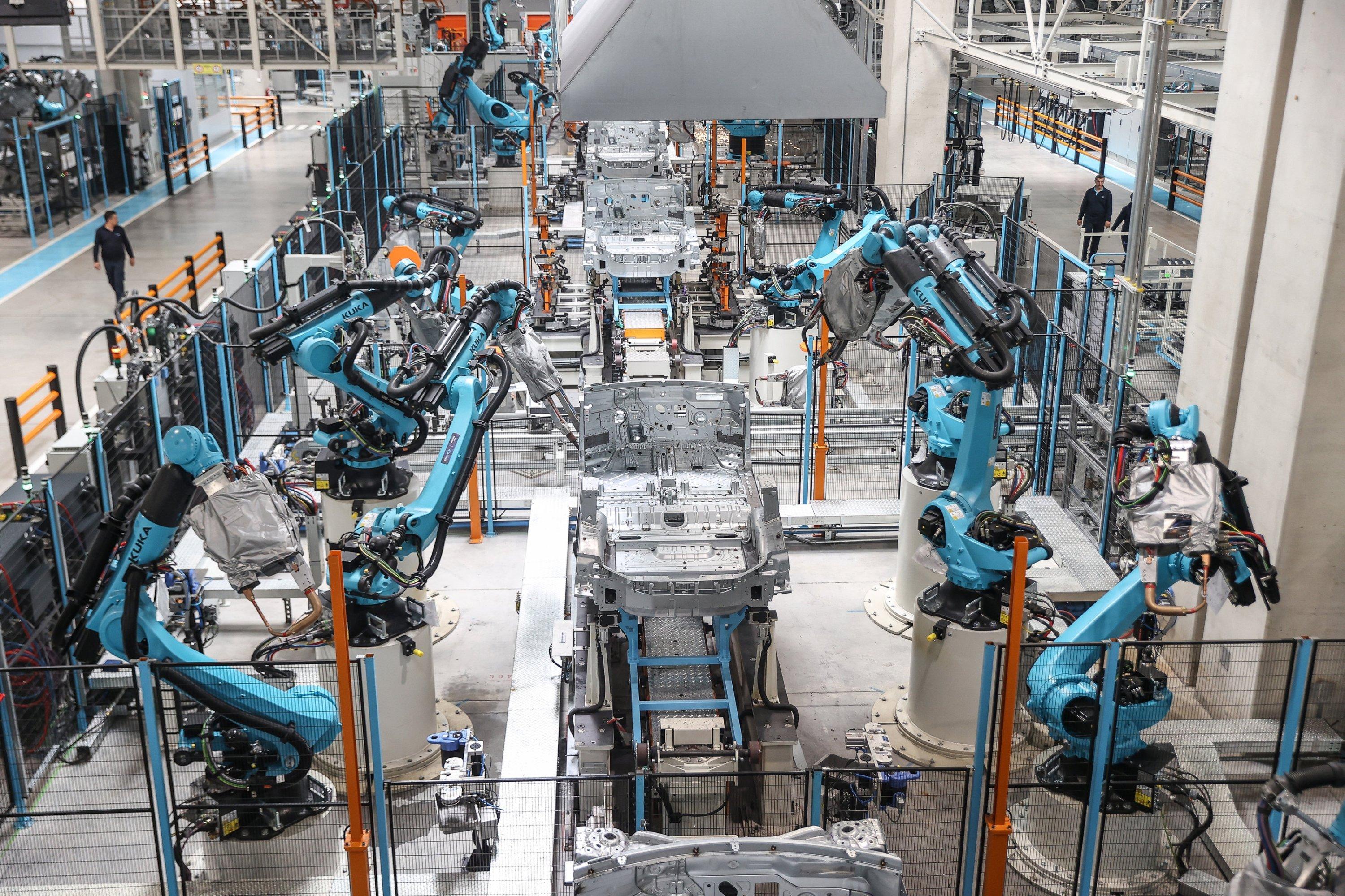 Industrial robot arms and automated machinery inside a modern manufacturing factory in Turkey.